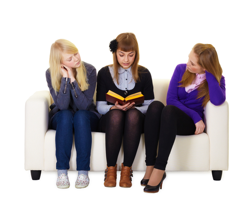 Three young ladies looking at a book